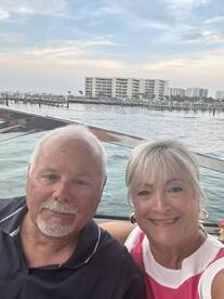 A happy couple enjoys a scenic moment on their boat, capturing the joy of their waterfront experience against a beautiful backdrop.