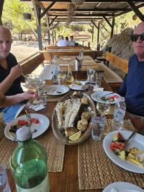 A delicious seafood feast is served at a dining area, featuring grilled fish and fresh salads, perfect for enjoying after a day on the water.