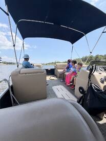 A cozy interior view of a pontoon boat featuring a family enjoying their time together. The spacious seating area is perfect for relaxing while cruising on the water.