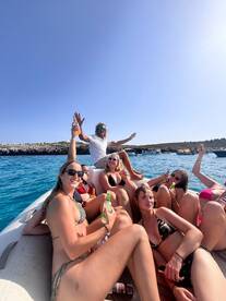 A lively group enjoys drinks and fun on a boat, capturing the essence of a perfect summer party at sea.