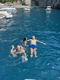 A joyful family enjoys a refreshing swim in crystal-clear waters, creating unforgettable memories on their boating adventure.