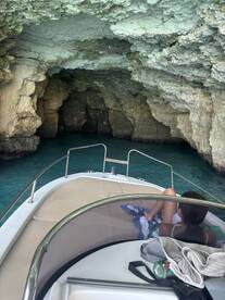 A scenic view from a boat entering a cave, showcasing the stunning rock formations and clear turquoise waters — perfect for adventure seekers exploring hidden gems.