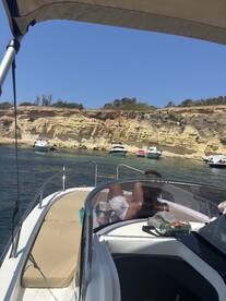 A relaxing moment on a boat with scenic cliffs in the background, perfect for enjoying the sun and water activities.