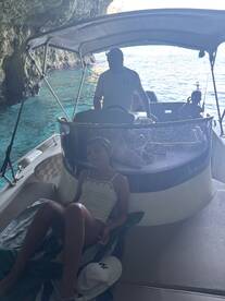 A relaxing moment aboard a boat inside a scenic cave, featuring a child enjoying the serene surroundings — perfect for family adventures on the water.