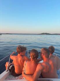 A family enjoys a serene sunset view from their boat, creating lasting memories on the water. Perfect for family outings and relaxation.