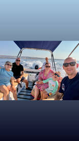 A joyful family enjoys a sunny day on a boat, capturing fun moments together — perfect for creating lasting memories on the water.
