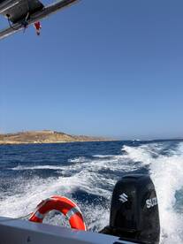 A scenic view from a boat cruising through vibrant blue waters, showcasing the coastline and creating a perfect backdrop for a day of adventure on the sea.