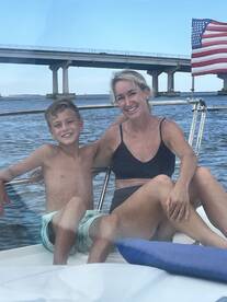A joyful moment captured on a boat with a mother and her son, enjoying their time together on the water — perfect for family outings and summer adventures.