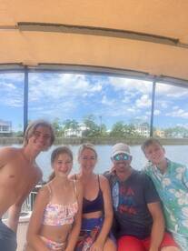 A cheerful family poses together on a boat, enjoying their time on the water — perfect for creating lasting memories during summer outings.