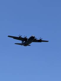An aircraft is captured flying against a clear blue sky, but the image does not relate to boating or water activities.