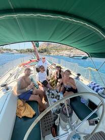 A lively group enjoys drinks and camaraderie aboard a sailboat, capturing the essence of a perfect day on the water.