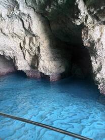 A stunning view of a cave with vibrant blue water, showcasing the natural beauty of the surroundings — perfect for eco tours and exploration.
