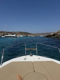 A view from the front of a boat showcasing the stunning turquoise waters and anchored vessels, perfect for a day of relaxation and exploration on the water.