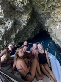 A group of friends enjoys a fun day on a boat inside a stunning cave, capturing the essence of adventure and camaraderie on the water.
