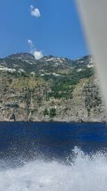 A stunning view of the Amalfi Coast from a boat, showcasing the dramatic cliffs and charming villages along the shoreline, perfect for scenic boat tours.