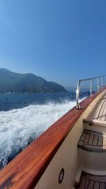 A scenic view of a boat in motion, showcasing the beautiful coastline and clear blue skies — perfect for adventure seekers and nature lovers.