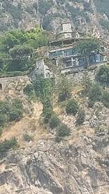 An unclear image of a structure on a hillside, lacking identifiable features or context.