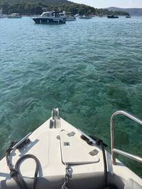 A clear view from the bow of a boat, showcasing the tranquil turquoise waters and surrounding vessels, perfect for a day of exploration on the water.