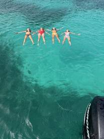 A group of friends floats together in the stunning turquoise waters, enjoying a perfect day of relaxation and fun under the sun.