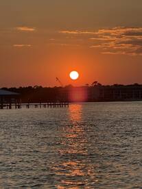 A stunning sunset casts a warm glow over the water, creating a picturesque reflection — perfect for capturing serene moments on the water.