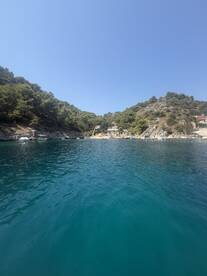 A serene view of a picturesque coastline with lush greenery and clear turquoise waters, perfect for exploring hidden harbors and enjoying nature's beauty.
