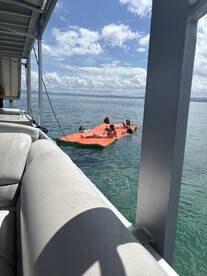A lively group enjoys a sunny day on a floating mat in the water, showcasing the fun and relaxation of a perfect boating experience.