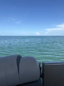 A close-up view of the seating area on a pontoon boat, showcasing the serene waters and clear blue sky — perfect for relaxing days on the water.