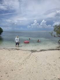 A group enjoys a relaxing day at the beach, swimming and floating in the clear waters — perfect for family outings or friends' get-togethers.