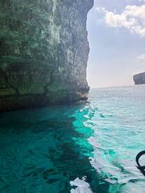 A stunning view of turquoise waters and rocky cliffs, showcasing the natural beauty of the coastline — perfect for eco tours and scenic boat trips.
