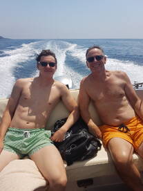 A father and son enjoy a sunny day on the boat, capturing a moment of relaxation and bonding on the water.