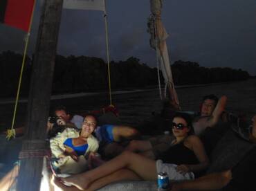 A group of friends relaxes on a boat during the evening, enjoying each other's company and the tranquil waters — perfect for a memorable night out on the water.