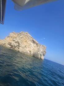 A stunning view of a rocky coastline under a clear blue sky, showcasing the beauty of the ocean and natural landscapes — perfect for adventure seekers and nature lovers.