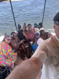 A joyful group of friends poses for a selfie aboard a boat, capturing the fun and camaraderie of their day on the water.