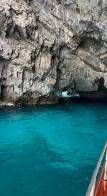 A stunning view of a rocky cave entrance surrounded by vibrant turquoise waters, perfect for exploring coastal wonders and enjoying nature's beauty.