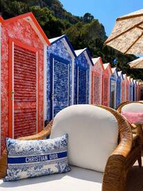 A vibrant scene featuring colorful beach huts and a stylish cushion, perfect for a summer getaway ambiance.