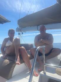A couple enjoys a sunny day on a boat, relaxing and soaking up the sun — perfect for a romantic getaway or a day of leisure on the water.