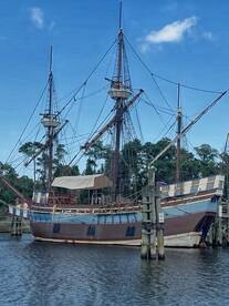 A majestic ship docked along the water, showcasing its impressive masts and classic design — a perfect sight for maritime enthusiasts.