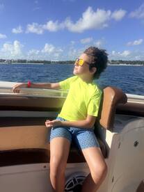 A young boy enjoys a sunny day on a boat, soaking in the views and relaxing in style — perfect for family outings on the water.