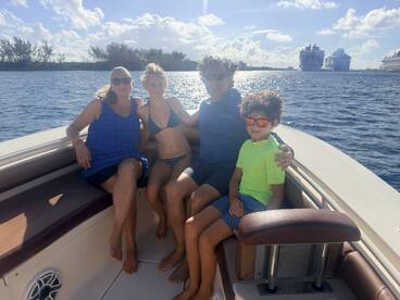 A joyful family enjoys a sunny day on the boat, creating lasting memories together on the water.
