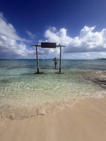 A woman enjoys a swing at Mansa Bay, surrounded by clear waters and sandy beaches — a perfect spot for relaxation and scenic views.
