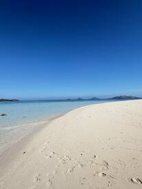 A stunning view of a pristine beach with soft white sand and crystal-clear waters, perfect for a relaxing getaway or beach day.