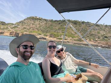 A cheerful group enjoys a sunny day on a boat, capturing the joy of outdoor adventures and camaraderie on the water.