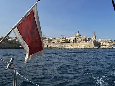 A picturesque view of the coastline featuring historic architecture, captured from a boat, showcasing the beauty of the destination.