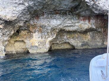 A stunning view of a rocky cave along the coastline, showcasing the natural beauty of the area — perfect for exploring by boat.