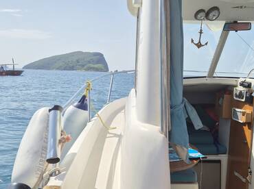 A glimpse inside the cabin of a boat, showcasing the seating area and helm, perfect for relaxing while enjoying the scenic views outside.