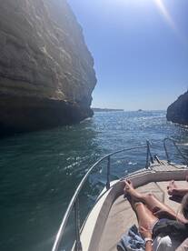 A scenic view from a boat navigating through a stunning coastal landscape, with guests relaxing on the deck — perfect for exploring beautiful waterways.