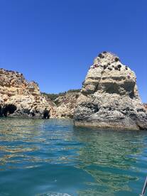 A stunning view of unique rock formations along the coastline, showcasing the natural beauty of the area — perfect for sightseeing and exploring by boat.