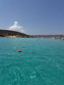 A vibrant scene of people enjoying the clear turquoise waters at a beach, perfect for swimming and relaxation under the sun.