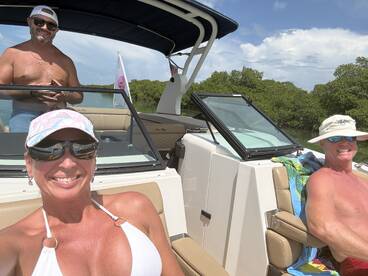 A cheerful group enjoys a sunny day on a boat, showcasing smiles and relaxation in a beautiful setting — perfect for a fun day on the water.