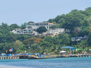 A vibrant harbor scene with colorful stalls and a picturesque coastline, showcasing the lively atmosphere of the area.